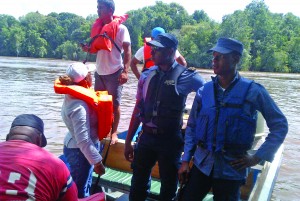 Coast Guards look on as Transport Minister Robeson Benn (not seen in photo) and other officials visit Crab Falls, Mazaruni, Regoin Seven crash site on Wednesday