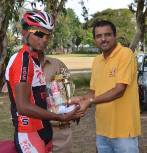  Winner Raynauth Jeffrey receives his hamper and trophy from Ricks and Sari Agro Industries’ accountant, Shahzir Ali