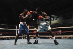 Young Richard Williamson (right) attacks the head of his trainer, Orland ‘Pocket Rocket’ Rogers during Friday evening’s card at the Cliff Anderson Sports Hall.