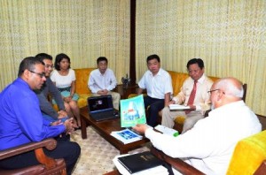 President Donald Ramotar reviewing business plans presented by Chairman of the China Forest Industry Group Company Ltd Whenze Chu and officials of Bai Shan Lin Forest Development Inc in the presence of Minister of Natural Resources and the Environment Robert Persaud