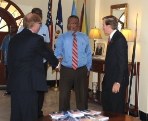 Canadian High Commissioner David Devine greets Prime Minister Samuel Hinds at the reception held at the U.S. embassy in Georgetown. Ambassador D Brent Hardt looks on