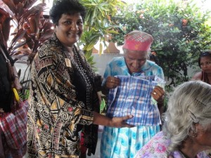 Valini Yacoob of GUYFUSE (left) presents a gift bag to an elderly Bush Lot resident