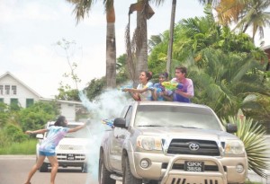 Celebrants launch a friendly attack as they drove by with their water guns,  and the lone bystander responds in the spirit of Phagwah 