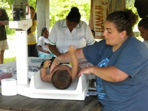 Ve'ahavta volunteer Bekkie Vineberg (right) weighs a pediatric patient on the Guyana Medical Mission to Guyana