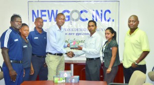 Trevor Basoo (third from right) hands over new camera equipment to Dion Inness in the presence of a few referees and general secretary of the referees' council Dwayne Lovell (extreme right)