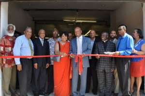 Guyana's Ambassador to the U.S. Bayney Karran cutting the ribbon to officially declare open the new Laparkan office in Brooklyn. Also in photo are company officials and members of the Diplomatic community in N.Y.