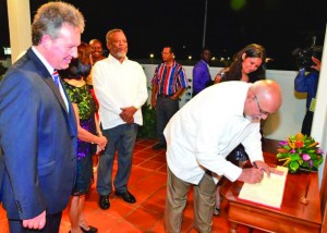 President Donald Ramotar writes a congratulatory birthday note for Her Majesty, Queen Elizabeth II as British High Commissioner Andrew Ayre looks on approvingly