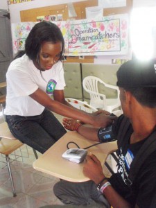 Miss Guyana World 2013 Ruqayyah Boyer testing a resident’s blood pressure