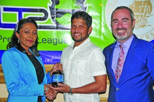 Demerara Distillers Limited Marketing Director Sharda Veeren-Chand hands over a bottle of El Dorado rum to captain of the Guyana Amazon Warriors, Ramnaresh Sarwan. Commercial director and consultant of the Limacol CPLT20, Jamie Stewart (right) also shares the moment 