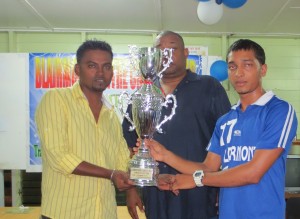 Deveshwari Prashad (right) collets the Cricketer-of-the Year trophy from President of the BCCC, Shabeer Baksh. In the background is Hilbert Foster