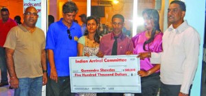 Guyana’s youngest world champion in powerlifting, Gumdendra Shewdas (third from right), poses with his cheque and members of the IAC at last Saturday evening’s function