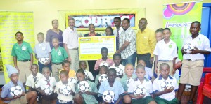 Officials of Courts (Guyana) Inc, Banks DIH Limited, the Petra Organisation, the Education Ministry and students of some of the participating schools pose with the sponsorship cheque during Wednesday’s launch (Photo: Avenash Ramzan)