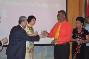 Prime Minister Samuel Hinds, who is performing the duties of president, and Chinese Ambassador to Guyana Zhang Limin toast to relations between Guyana and China at the 64th anniversary of the founding of the People’s Republic of China. Also in photo are Mrs Hinds and Mrs Zhang