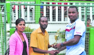 Christopher Barnwell collects his Man-of-the-Match trophy from DDL/Pepsi Brand Manager Larry Wills while another staff member from DDL looks on (Rajiv Bisnauth photo)