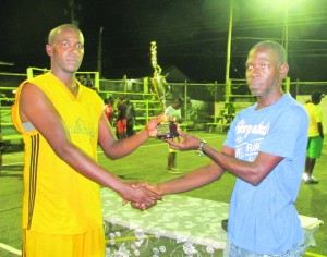 Omally Sampson (left) receives his MVP award from Ashton Angel at the presentation ceremony held after the finals