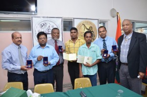 Deputy Bank of Guyana Governor Dr Gobind Ganga; Finance Minister Dr Ashni Singh; Prime Minister Samuel Hinds; coin designers Courtney Douglas and Adrian Juman; Culture Minister Dr Frank Anthony; and junior Finance Minister Juan Edghill display the commemorative coins they were presented with on Friday at the launch