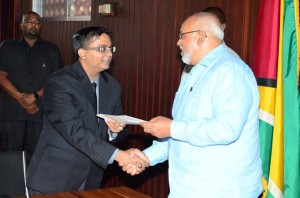 Newly-appointed GECOM Commissioner Athmaram Mangal receives his instrument of appointment from President Donald Ramotar