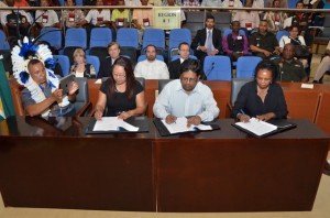 From left to right: National Toshaos Council Chairman Derrick John looks on as Amerindian Affairs Minister Pauline Sukhai, Finance Minister Dr Ashni Singh and UNDP Resident Representative Khadija Musa sign the Amerindian land titling agreement