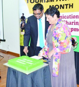 Acting Tourism Minister Irfaan Ali and Tourism and Hospitality Association of Guyana representative Andrea De Caires, cutting a cake at the launch of Tourism Awareness Month