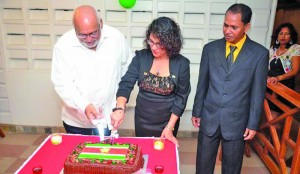 Surinamese Ambassador Nisha Kurban, President Donald Ramotar and the ambassador’s husband cut a cake to mark Suriname’s 38th independence anniversary