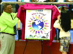 Prime Minister Samuel Hinds assisting in the unveiling of the e-booklet cover during an energy forum