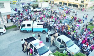 Citizens congregate near the scene of the shootout between a businessman and police. Four persons were shot dead including two policemen. The gunman was eventually shot dead by police after tear smoke was used in the drama which lasted several hours (Carl Croker and Treiston Joseph photos)   