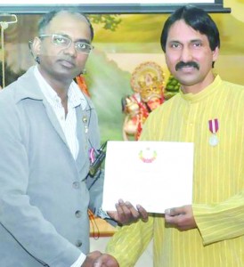 Narine Dat Sookram (left) honouring one of the recipients Devanand Ram