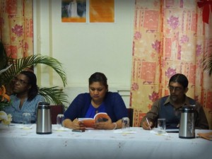 Minister of Education, Priya Manickchand (centre) previews the new book at the launch alongside Chief Librarian of the National Library Gillian Thompson (L), and the book’s author Petamber Persaud (R)