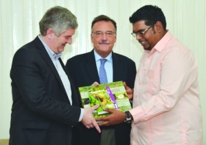 Acting Tourism Minister Irfaan Ali presenting books on Guyana to Argentine Tourism Ministry Undersecretary of Tourism Quality Gonzalo Casanova Ferro while another member of  the Argentine delegation looks on