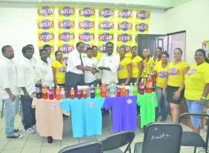 Beverage boss, Robert Selman presents a cheque to the President of the Enterprise Busta Sports Club, Karran Ramdhoon in the presence of other club members and staff