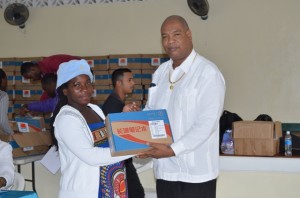 Junior Finance Minister Juan Edghill handing over a laptop to a beneficiary of the One Laptop Per Family (OLPF) programme at Tipperary Hall in Buxton