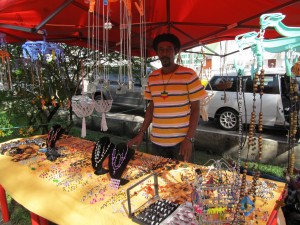 Junior displaying knitted flower baskets and handmade jewellery