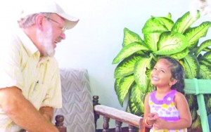 Dennis LeBlanc, a former minister who now directs Greenfield’s Pastoral Counselling Centre, spends time with a little girl who is an orphan in Guyana 