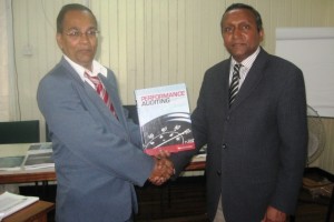 Lal (right) donates auditing books during a trip to Guyana in 2010