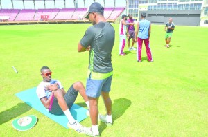 Sewanrine Chattergoon assists Ronsford Beaton in doing his portion of sit-ups (Photos: Rajiv Bisnauth)