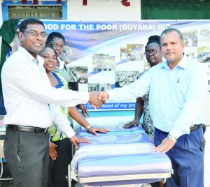 Food For The Poor Chairman Kent Vincent hands over supplies to CMO, Dr Shamdeo Persaud while representatives from the medical institutions look on