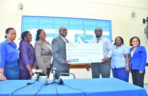 GT&T Chief Financial Officer Justin Nedd (third from right) handing over the cheque to Chief Education Officer Olato Sam at the company’s head office on Brickdam, Georgetown on Friday 