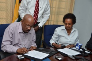 Local Government and Regional Development Minister Norman Whittaker and United Nations Development Fund’s Resident Coordinator Khadija Musa signing the agreement