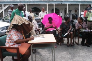 Councillors shelter under umbrellas during their outdoor meeting
