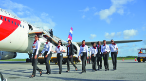 Newly-trained flight attendants of Dynamic Airways walk off the Cheddi Jagan International Airport tarmac shortly before they were officially introduced to members of the media at a news conference (Carl Croker photo)  