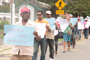 Former Local Government Minister Ganga Persaud bearing a placard outside GECOM, last month. 