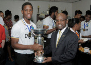 Shimron Hetmyer and Minister Stephen Lashley show off the World Cup trophy during the West Indies Under-19s arrival at the Grantley Adams International Airport in Barbados on Tuesday. (WICB Media Photo/Randy Brooks)