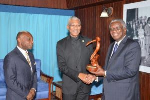 Barbados Prime Minister Freundel Stuart presents a gift to President David Granger for the people of Guyana, during a meeting at the Ministry of the Presidency on Wednesday morning. Guyana's Foreign Affairs Minister Carl Greenidge looks on. 