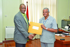 Minister of State, Joseph Harmon handing over the Terms of Reference (ToRs) to Major General (Retired) Joe Singh 