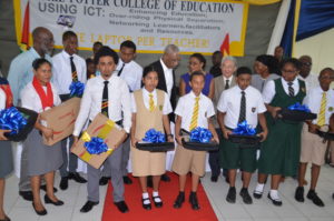 President David Granger and Telecommunications Minister Cathy Hughes pose with the first batch of beneficiaries of the One Laptop Per Teacher initiative