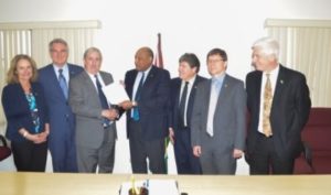 Natural Resources Minister Raphael Trotman (centre) receives the letter of notification from Jeff Simons, Country Manager of ExxonMobil along with representatives from Nexen Energy and Hess Corporation