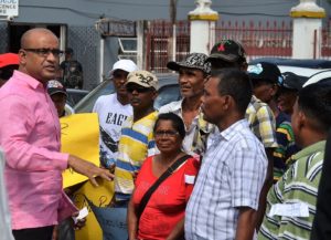 Opposition Leader Bharrat Jagdeo in discussion with a group of protestors on the first day of the Budget Debates in front of the National Assembly. 