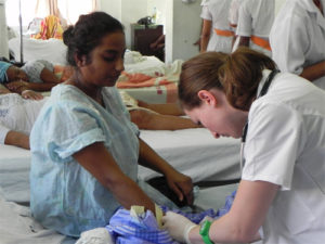 Rachel Pope, MD (right), inserts an IV line in a patient at Georgetown Public Hospital in Georgetown, Guyana, in January 2012 as part of the four-year WONDOOR program. Dr. Pope is an Ob/Gyn resident at UH MacDonald Women’s Hospital