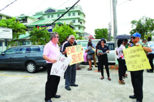 Social activist and Attorney-at-Law Christopher Ram and Director of Nations Incorporated, Dr Brian O’Toole holding up placards at Wednesday’s protest